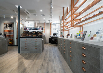 Cabinetry at Kryolan Covent Garden Store interior featuring grey cabinetry with brass cup handles
