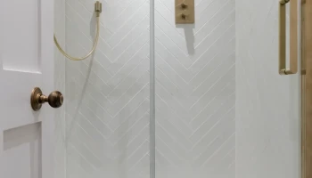 Luxury shower room at 21 Bedford Square luxury shower with white herringbone tiles and brass fittings